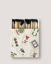 Matchbox with mahjong tile design on a light gray background
