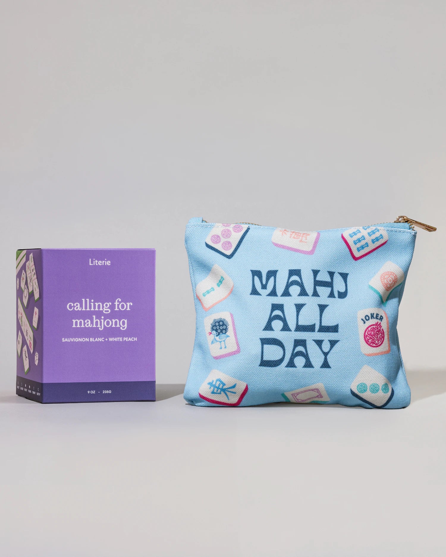 Blue pouch with 'MAHJ ALL DAY' text and purple candle  labeled 'calling for mahjong' on a light gray background