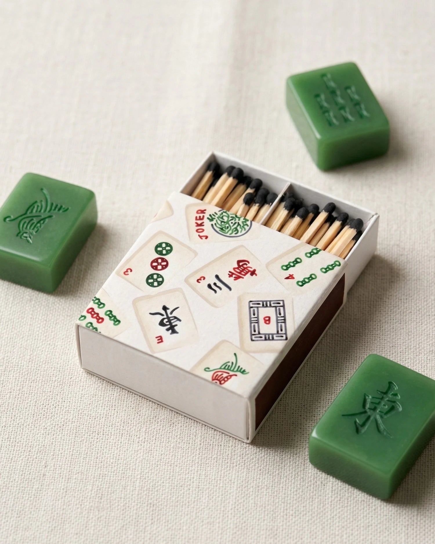 Matchbox with Mahjong tiles design on a light background