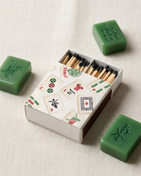 Matchbox with Mahjong tiles design on a light background