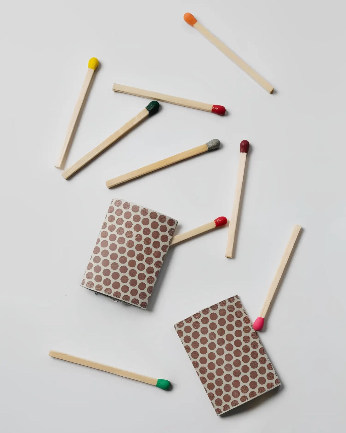 Two match striker pads with matches scattered around on a light gray background