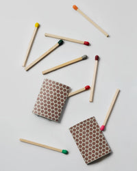 Two match striker pads with matches scattered around on a light gray background