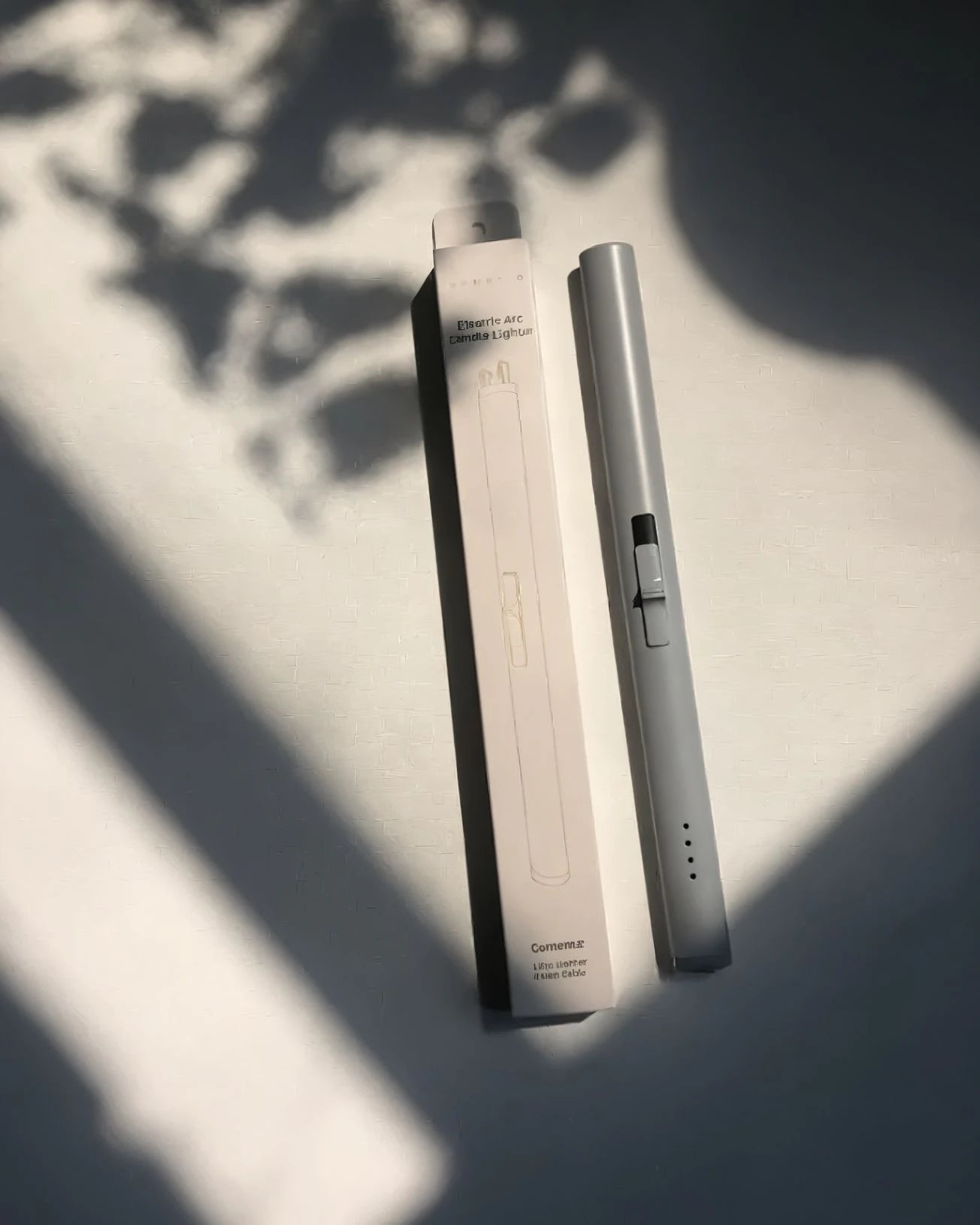 Electronic lighter and its packaging on a light surface with shadows