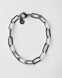 Silver chain bracelet on a light gray background