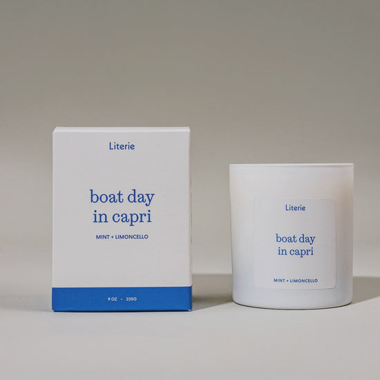 Candle and packaging of 'boat day in capri' spinning on light gray background