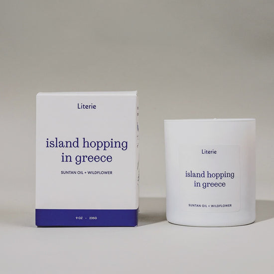"Island Hopping in Greece" candle and packaging rotating on a gray background.