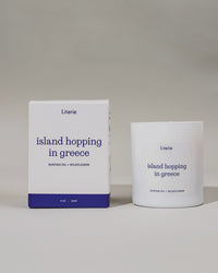 "Island Hopping in Greece" candle and packaging rotating on a gray background.