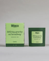 Wicked on Broadway candle named 'defying gravity on broadway' next to packaging spinning.
