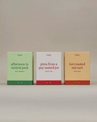 Literie's "I Love NY" candle trio spinning to show of product packaging illustrations on a grey background. 