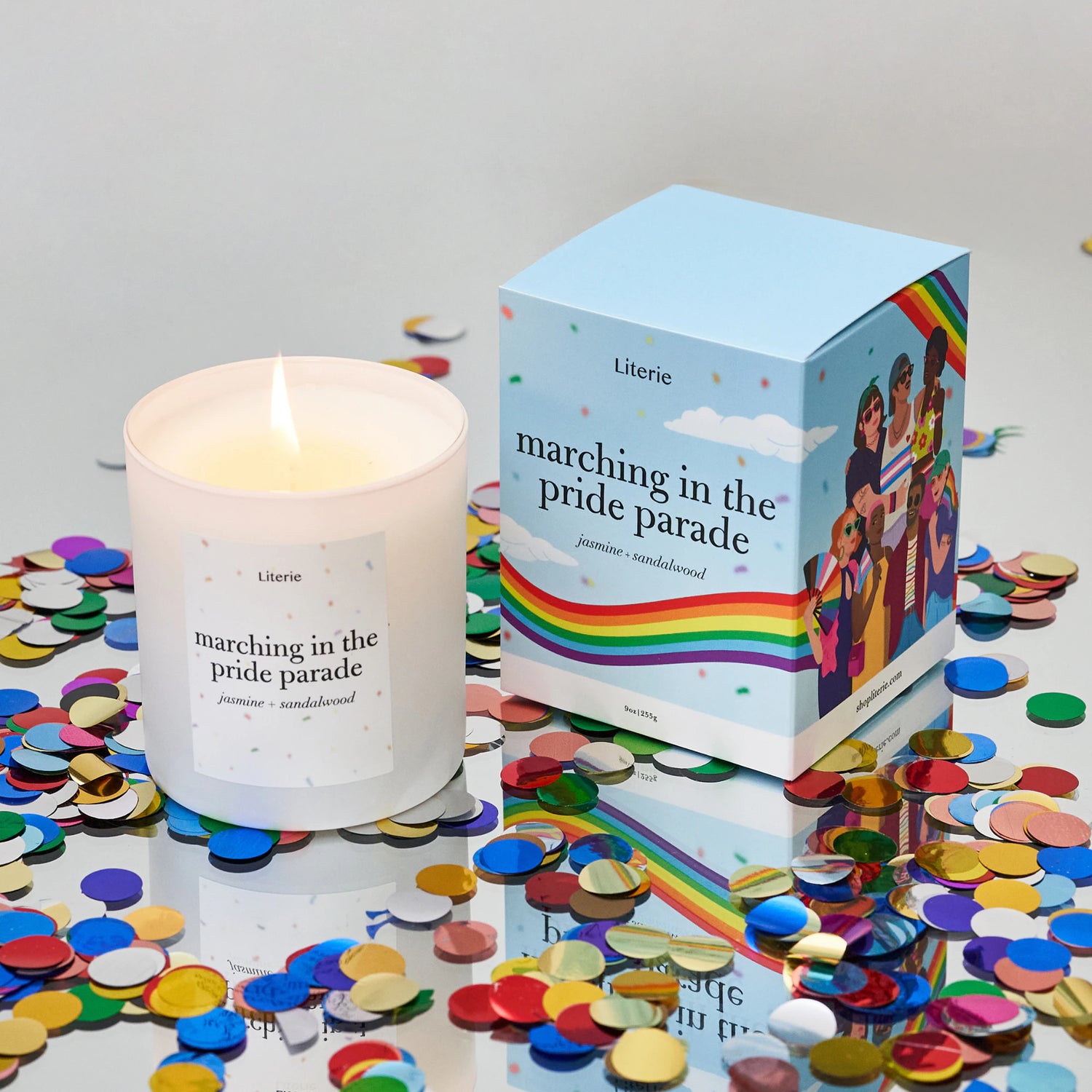 Lit candle and packaging titled 'Marching in the Pride Parade' on a surface with confetti.