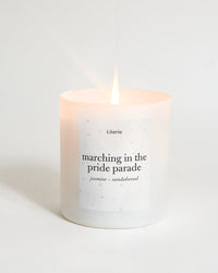 Candle with text 'marching in the pride parade' on a light background