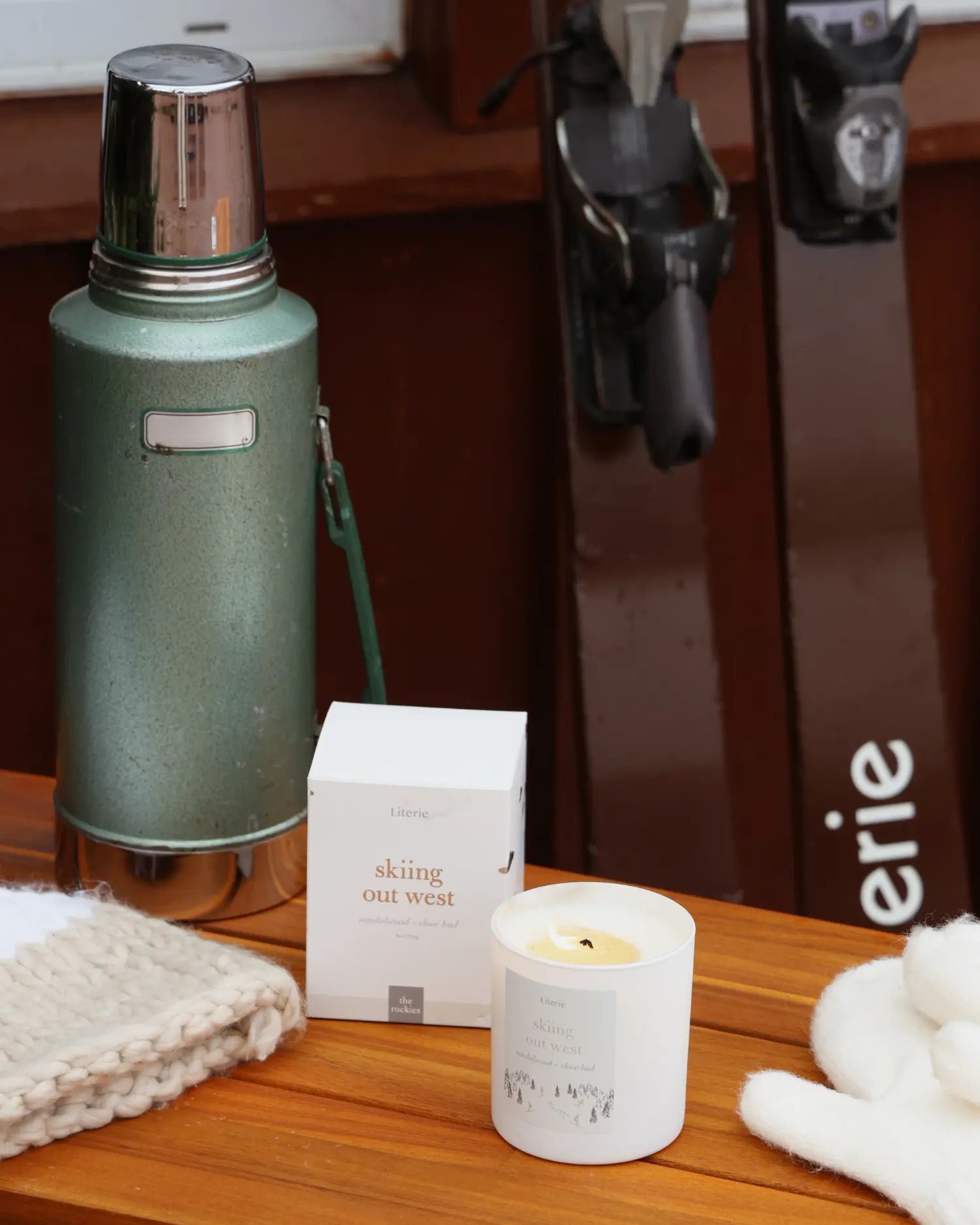 Green thermos, white box, and candle on a wooden surface with 'Literie' branding in the background.