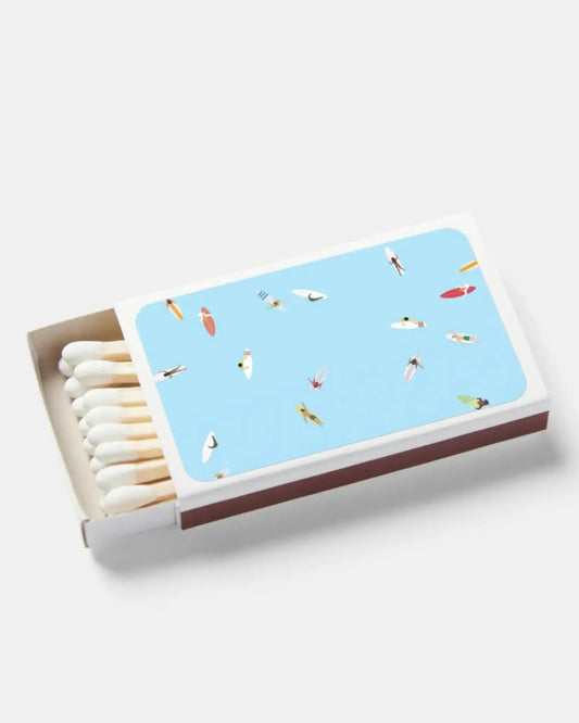 Matchbox with a blue design featuring small surf illustrations on a white background