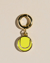 Tennis ball charm on a beige background