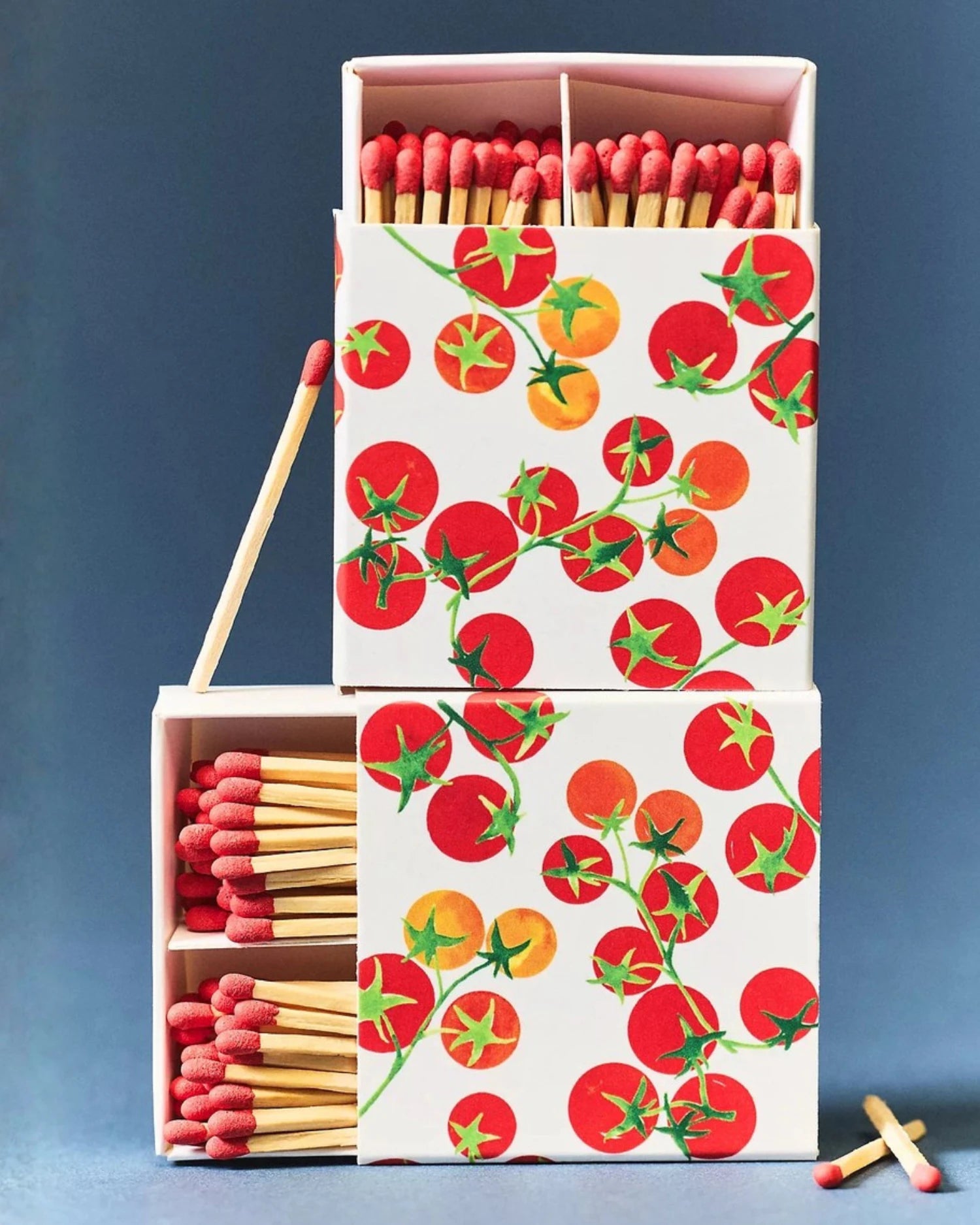 Matches in a box with tomato design on a blue background