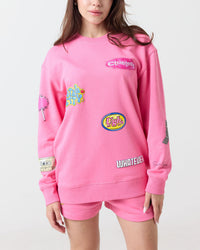 Person wearing a pink sweatshirt with various graphics and text on a white background