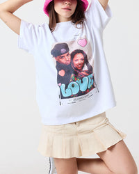 Person wearing a white t-shirt with a graphic design and a pink bucket hat on a plain background