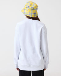 Person wearing a white sweatshirt and yellow checkered hat on a white background