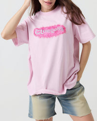 Person wearing a pink t-shirt with a logo on a white background