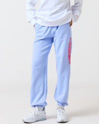 Person wearing a white sweatshirt and light blue pants with a logo on a white background