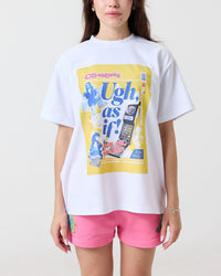 Person wearing a white t-shirt with a colorful graphic design from Clueless on a plain background