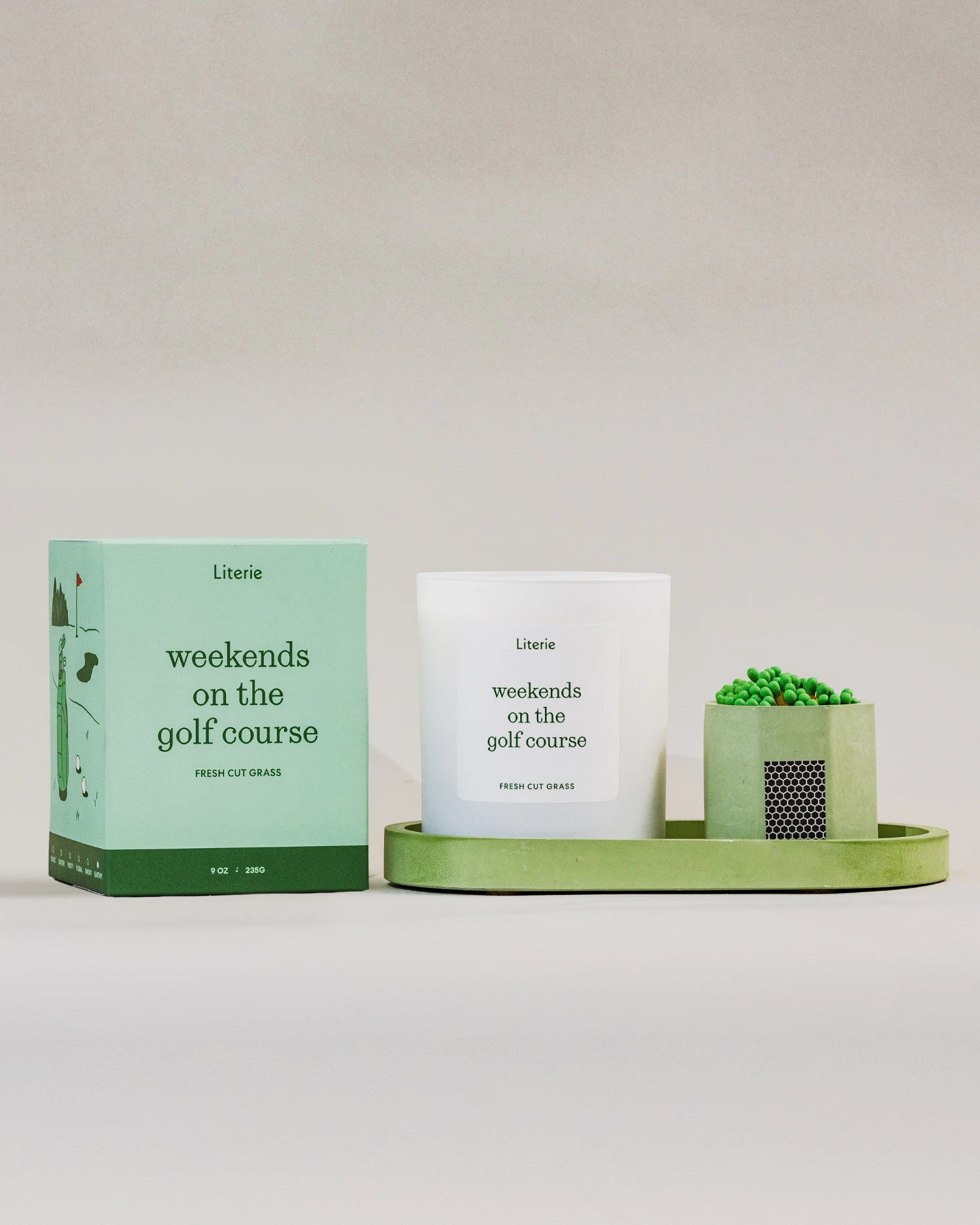 Literie golf candle and packaging on a green tray with matches against a white background,