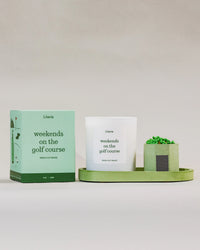 Literie golf candle and packaging on a green tray with matches against a white background,