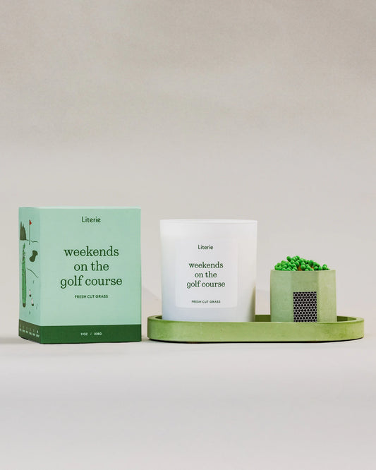 Literie golf candle and packaging on a green tray with matches against a white background,