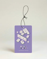 Purple air freshener with white and green mahjong pieces and 'where are the jokers' text on a beige background