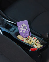 Purple mahjong air freshener with mahjong tiles in a car.