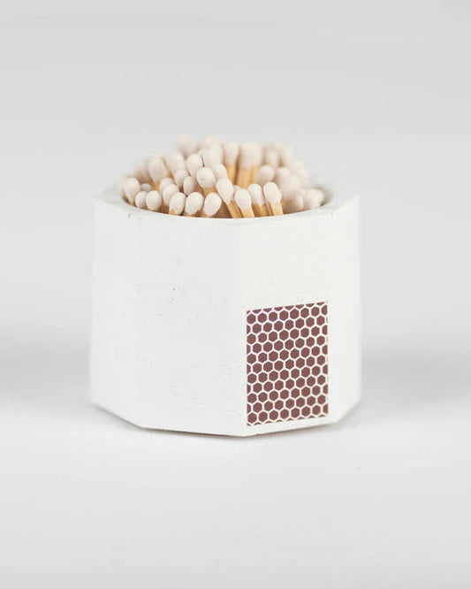 White match container with striker and filled with wooden matches on a white background