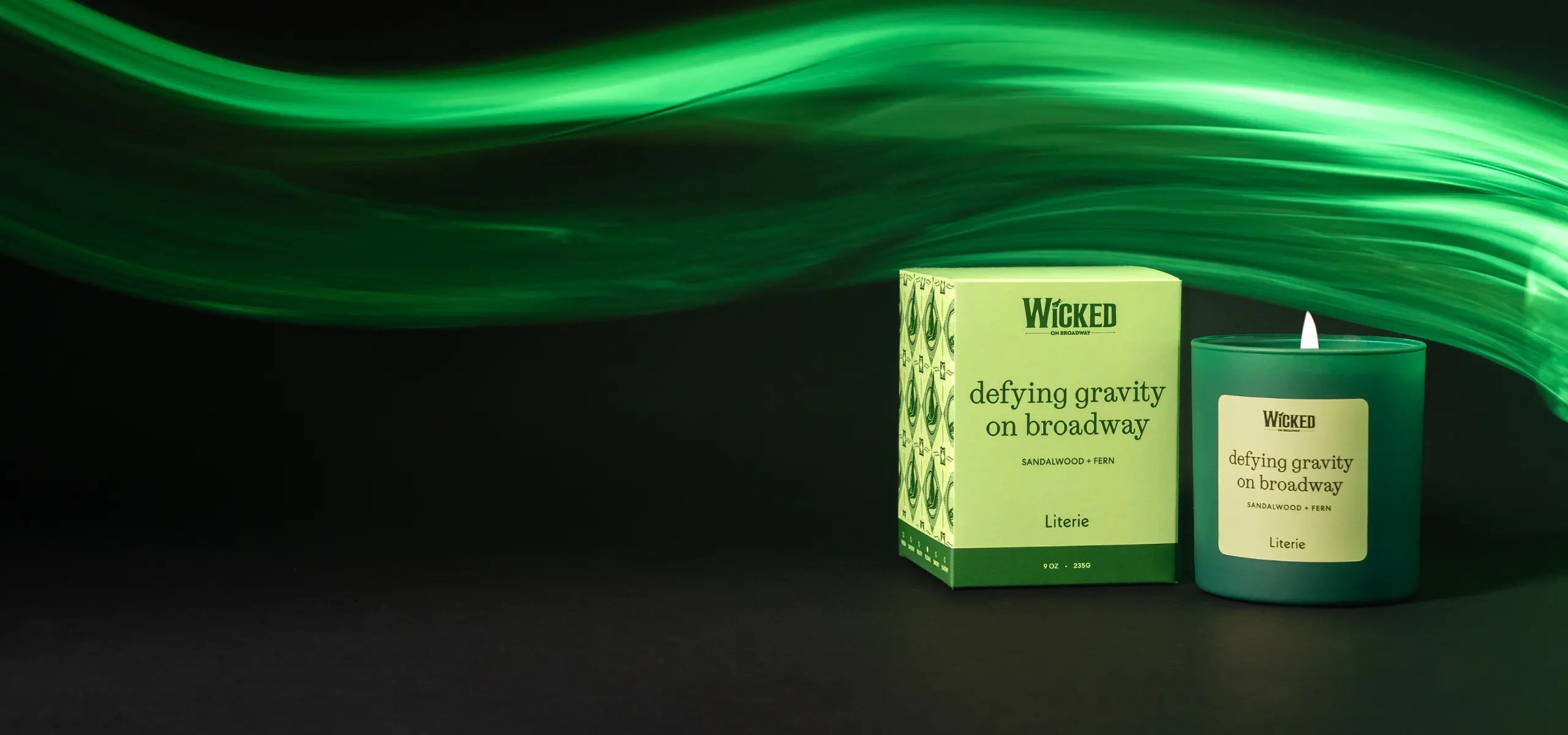 Wicked on Broadway by Literie candle and packaging on a black surface with green lighting.