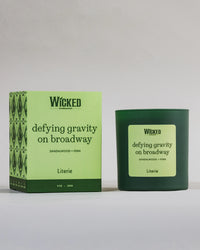 Wicked on Broadway candle named 'defying gravity on broadway' next to packaging.